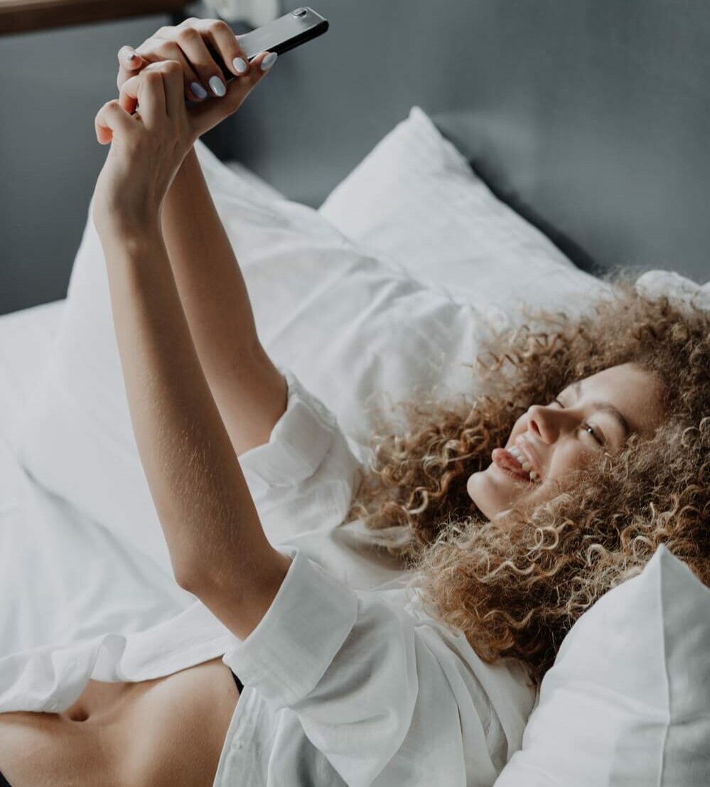 mujer-feliz-cama-sexting